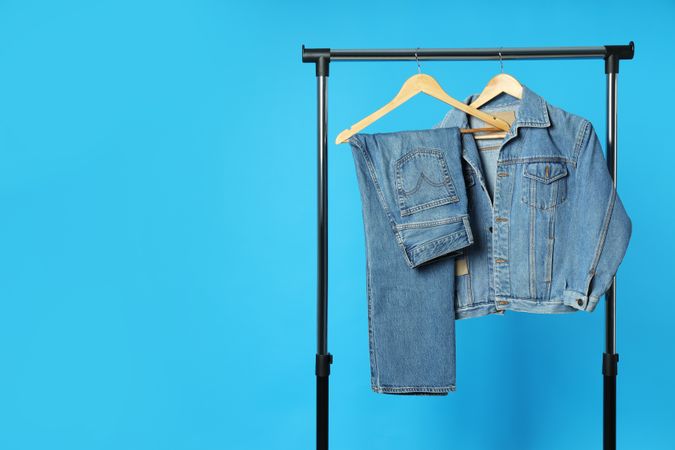 Jeans hang on hangers on a blue background