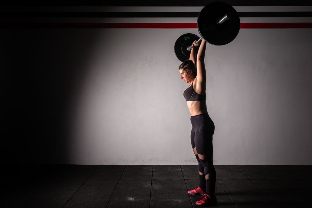Woman lifting barbell in gym