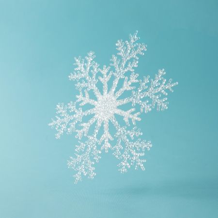 Single large snowflake on bright blue background