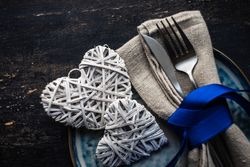Blue ribbon wrapping cutlery with heart decorations