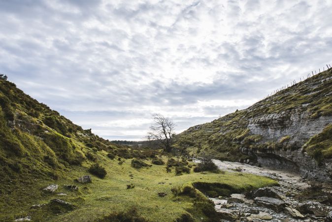 Valley between hills and cloudy sky