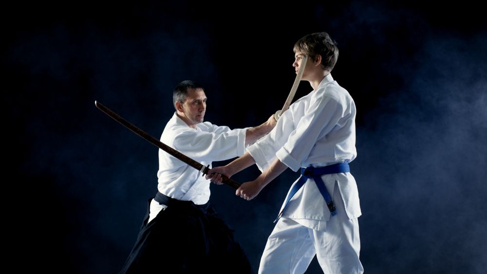 Martial Arts Master Teaches His Young Student How to Fight with Wooden Sword Bokken.