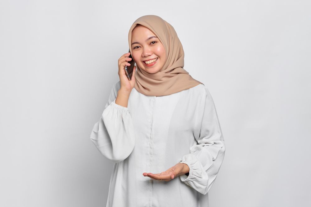 Asian Muslim woman having a nice conversation on her cell phone