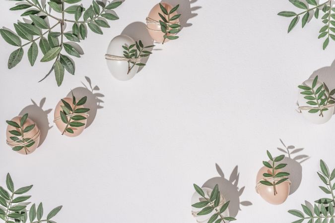 Brown eggs wrapped in leaves scattered on light  background