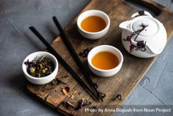 Asian tea time concept of tea pot and loose leaf tea on board bGp7e0