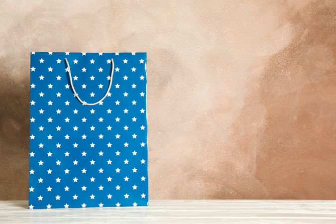 Present bag on table against brown background, copy space