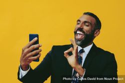 Energetic Black businessman in suit gesturing at smartphone screen 4jLd80