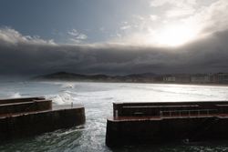 Rock breakwater with raging sea on cloudy weather