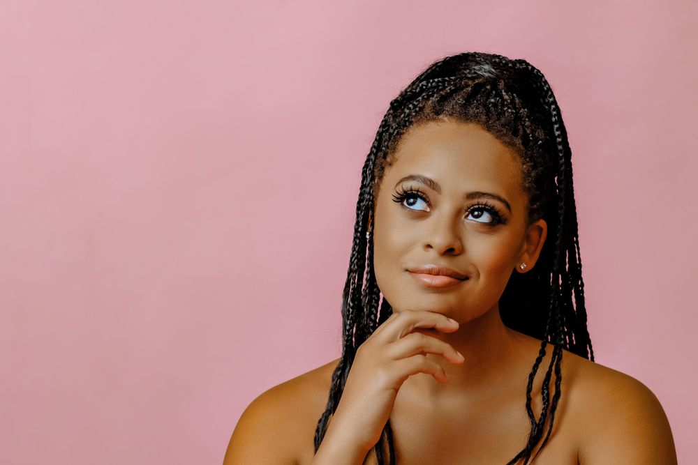 Thoughtful female looking at camera in pink studio shoot