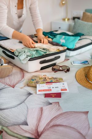 Unrecognizable woman preparing suitcase for summer holidays