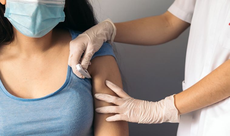 nurse putting thermometer to young female patient