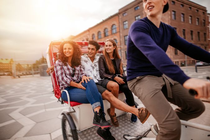 Group of friends in passenger tricycle smiling and looking away from camera