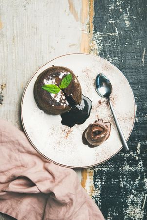 Top view of molten chocolate cake with mint garnish on plate
