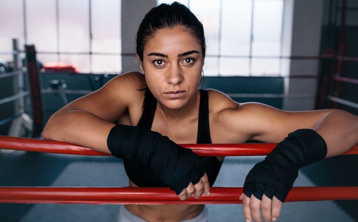 Female boxer inside a boxing ring with hands wrapped