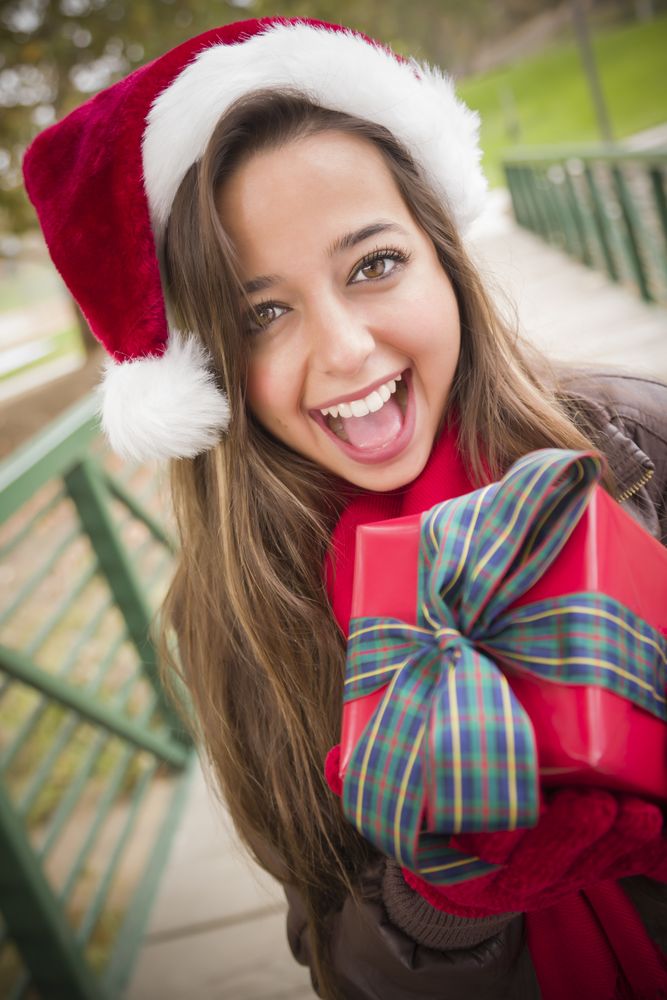 Woman Wearing a Santa Hat with Wrapped Gift