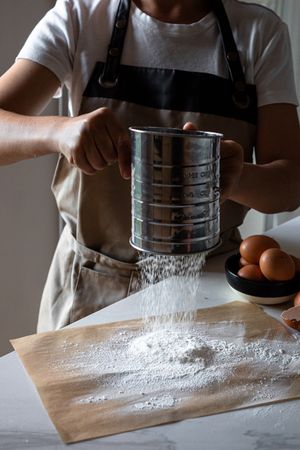 Faceless cook preparing flour and eggs for cooking