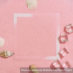 Pink sand with paper square outline and ice cubes, palm leaf and sea shells 4Bjyd4