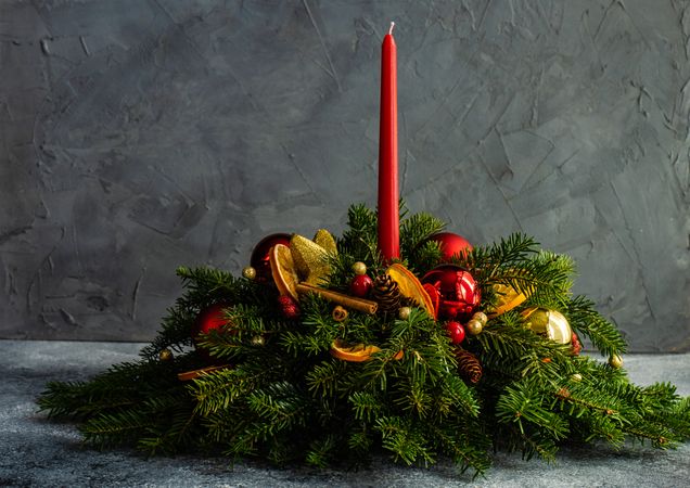 Side view of red and gold Christmas decorations in pine branch on table