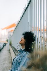 Happy Black female by metal fence