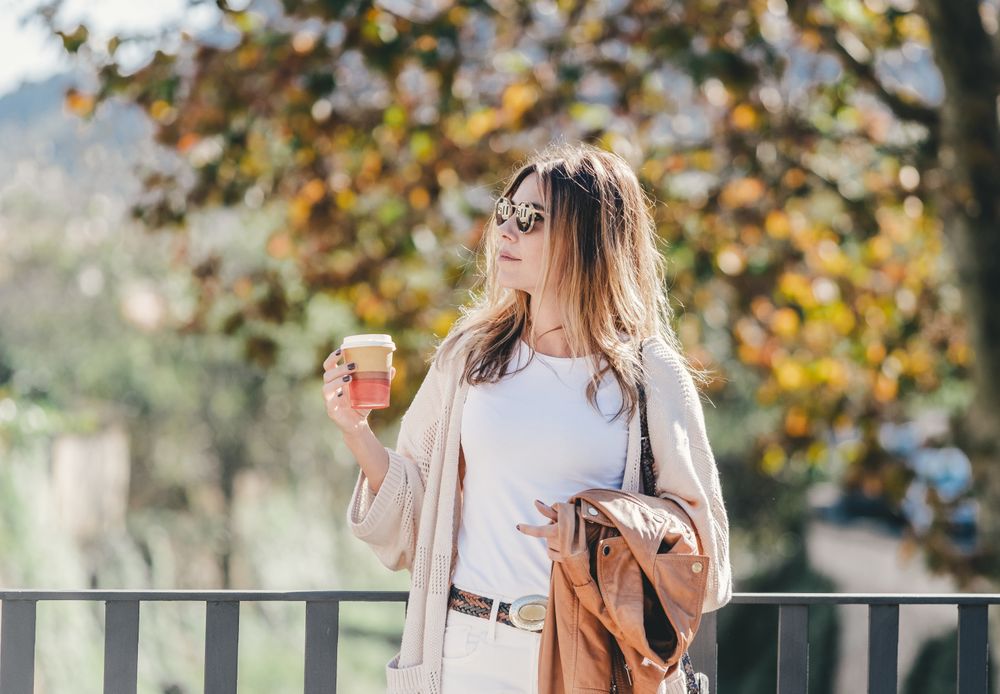 thoughtful woman leaning on handhold and looking along