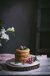 Pile of raspberry pancakes with honey on plate