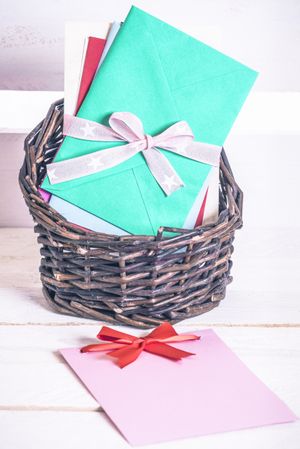 Basket with colorful envelopes and paper notes with bows