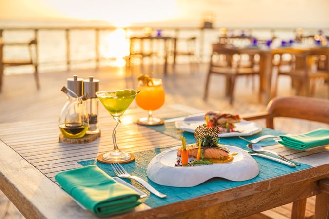 A dinner table with cocktails by the ocean