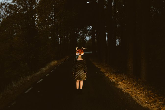 Woman in red fox mask on road