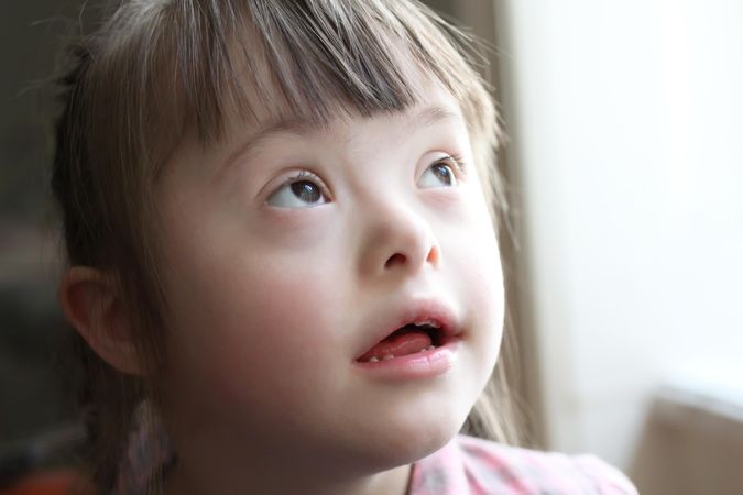 Portrait of a girl with Down syndrome looking up