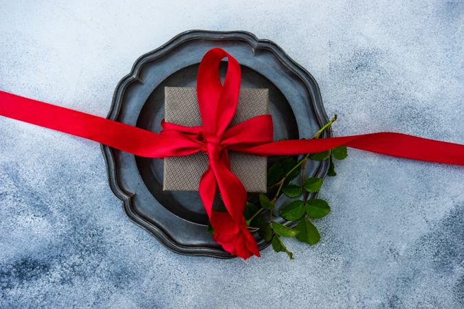 Red ribbon wrapped giftbox on table setting