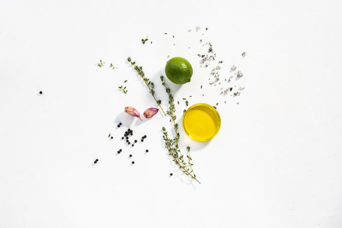 Thyme, lime, garlic, salt, pepper and olive oil flat lay