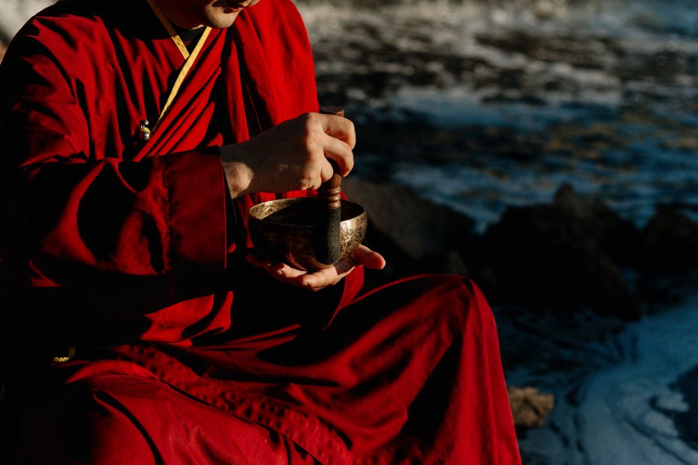 Cropped image of Buddhist monk holding a Tibetan singing bowl