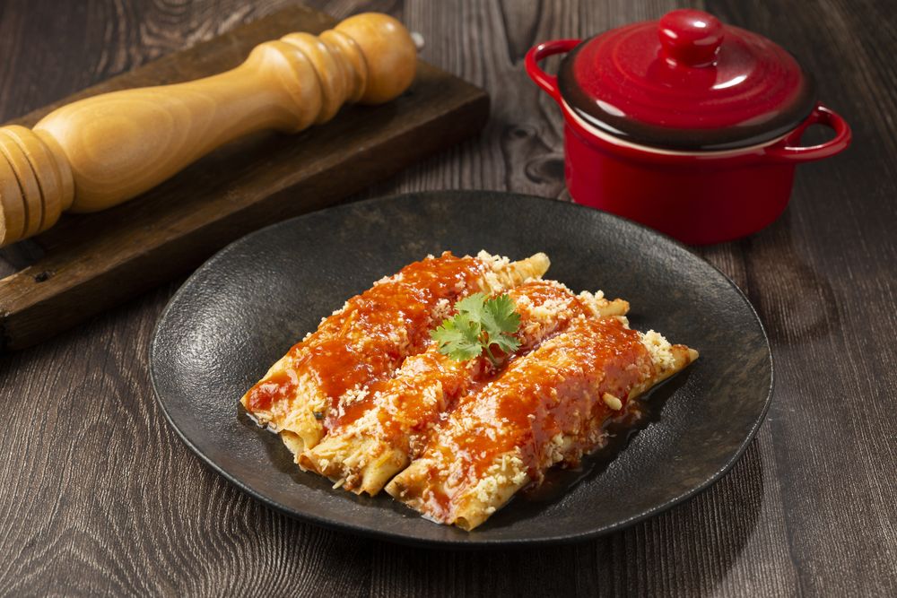 Pancakes stuffed with minced meat and topped with tomato sauce and grated cheese.
