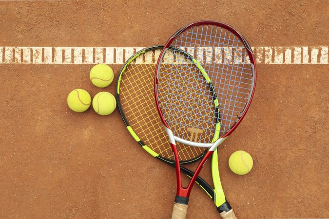 Tennis racquets with tennis balls on clay court