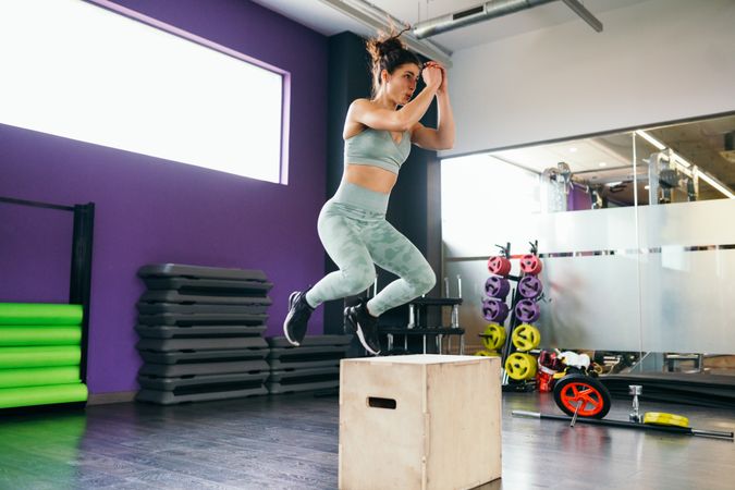 Woman jumping on a box exercising legs