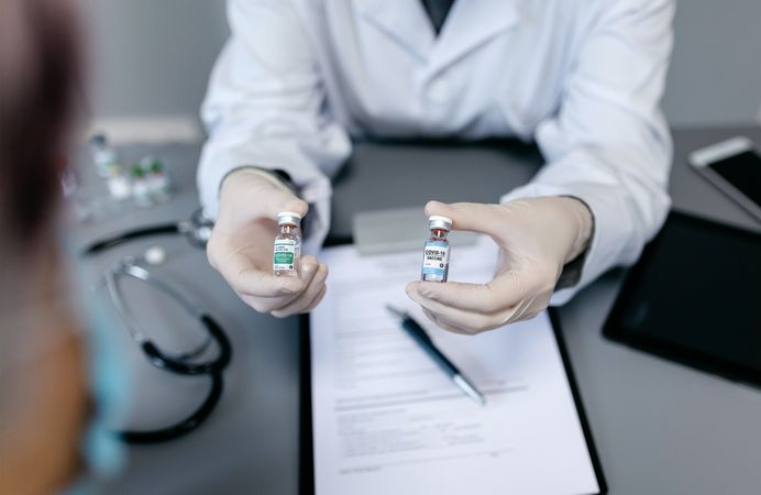 Doctor showing her patient two different coronavirus vaccine options