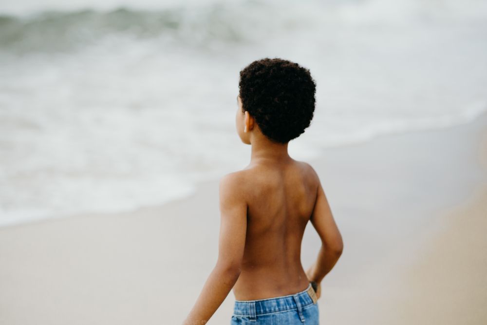 Black boy playing on beach
