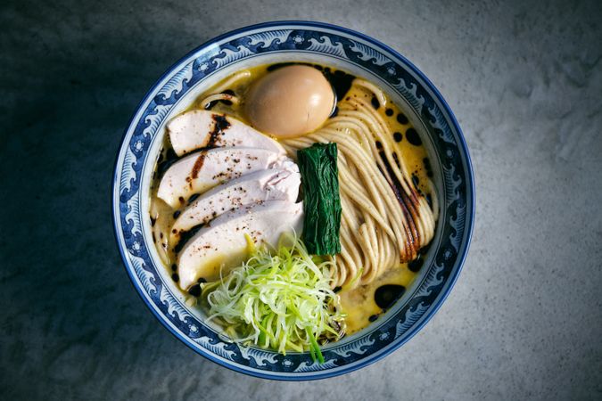 Tasty ramen with cooked noodles and fresh vegetables in bowl