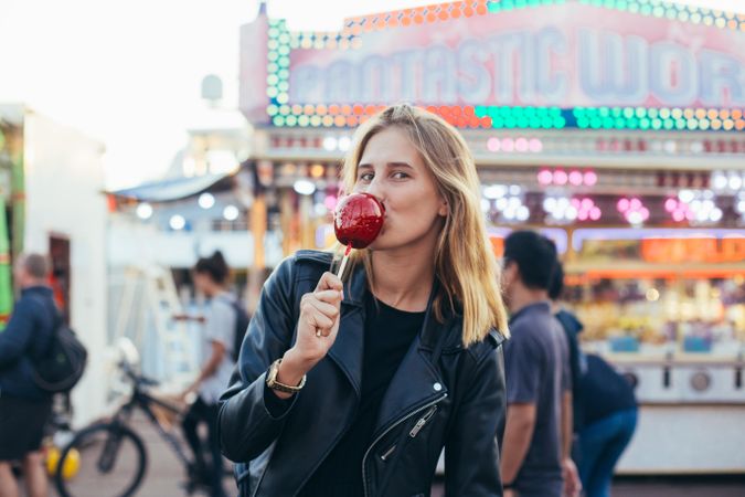 Woman taking a bite of a candied apple