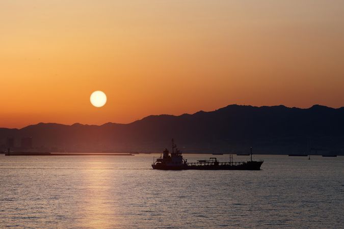 Orange sunrise over a boat in Japan