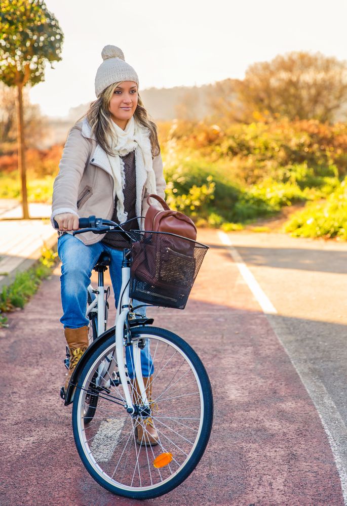 Woman sitting on bicycle in a bike lane on sunny winter day