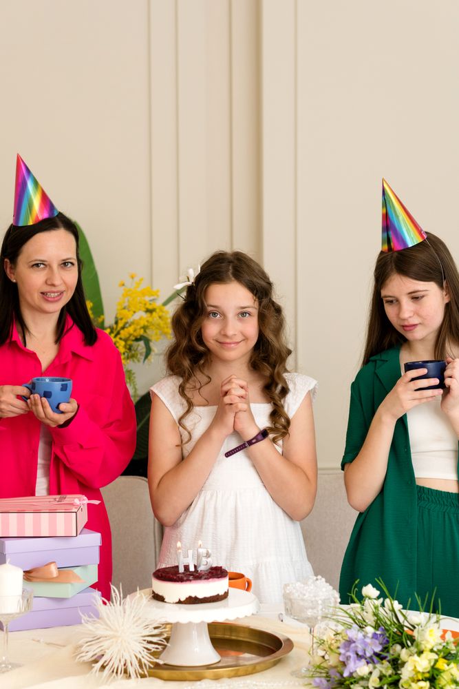 Birthday girl in white dress, surrounded by family