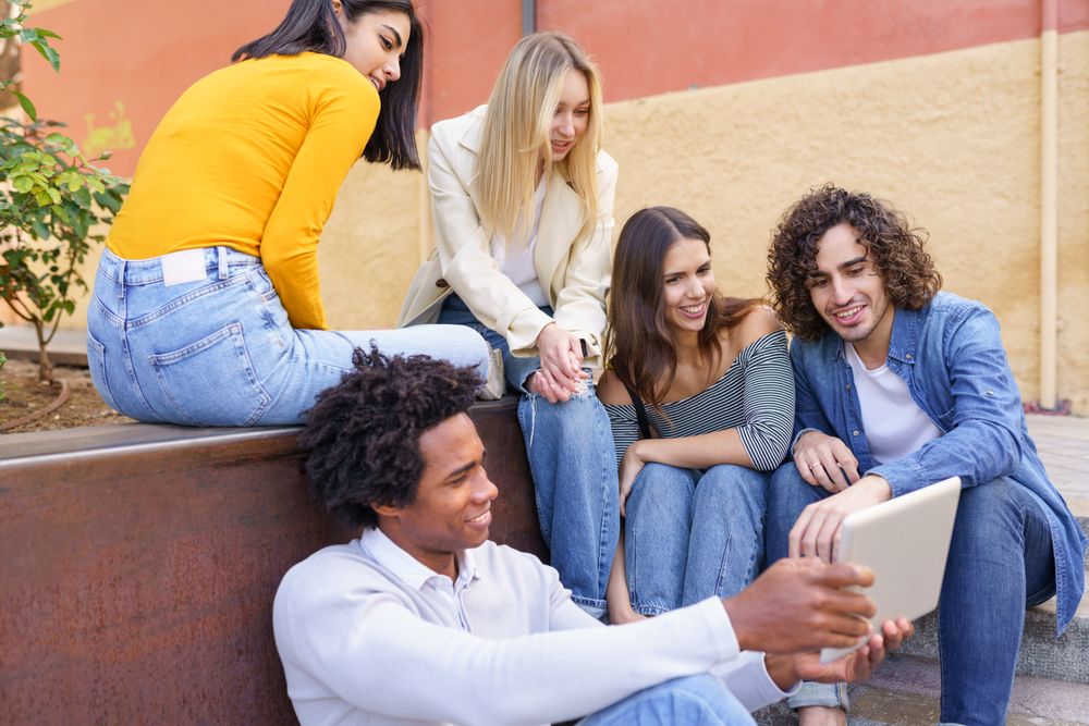 Friends watching something on a digital tablet outside