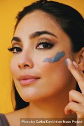Close up of Latina woman applying clay mask with hand 5a6zo4