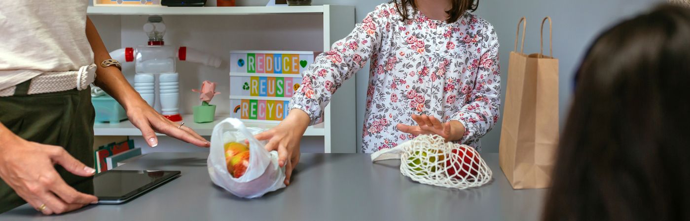 Student putting aside disposable plastic bag in ecology classroom.