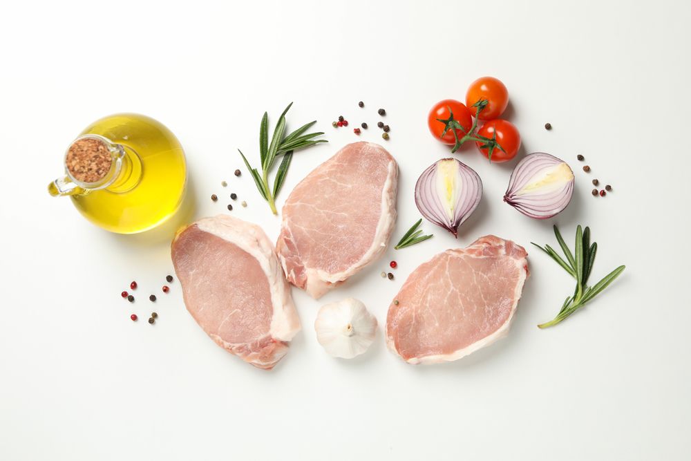 Composition with raw meat and ingredients on light background, top view