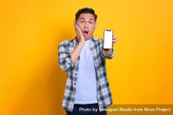 Surprised Asian male holding up smart phone with blank screen 5oeXgb