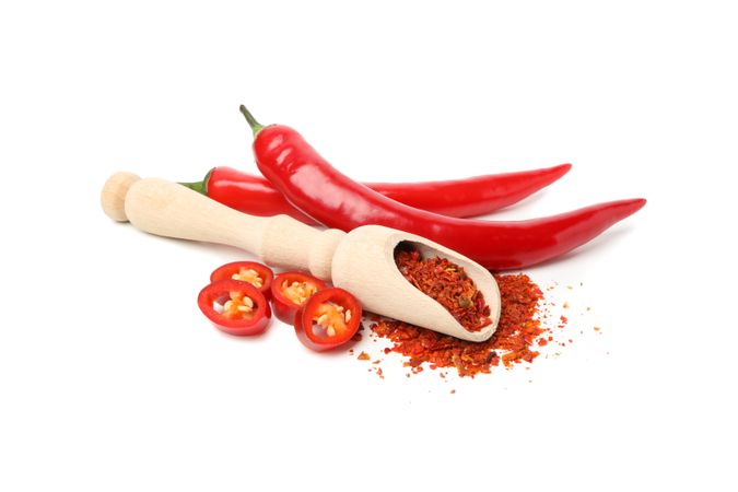 Scoop with spice and chilli peppers isolated on blank background