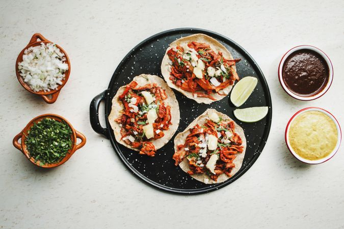 Pepper and lime near tacos al pastor and sauces