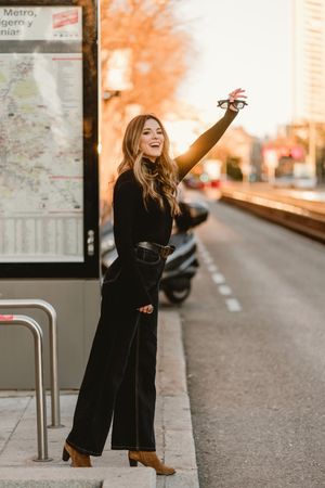 Cheerful woman hailing taxi